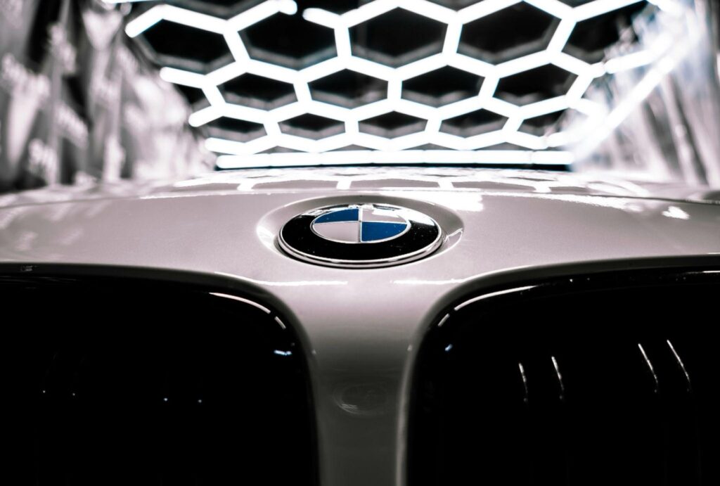 BMW roundel on a bonnet under hexagonal workshop lighting