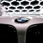 BMW roundel on a bonnet under hexagonal workshop lighting
