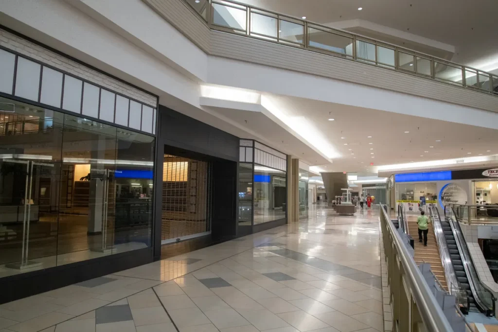 Spacious and contemporary mall interior with closed stores and escalator