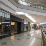 Spacious and contemporary mall interior with closed stores and escalator